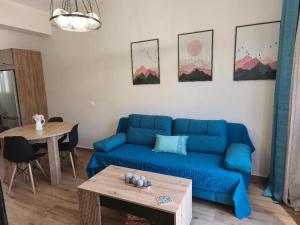 a living room with a blue couch and a table at Amazing View Studio in Chorepískopoi