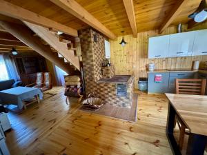 a kitchen and living room with a fireplace in a house at Miejsce w lesie in Stara Huta