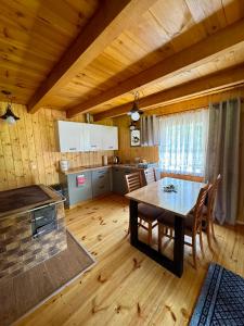 a kitchen and dining room with a table and chairs at Miejsce w lesie in Stara Huta +30 photos