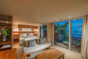 a bedroom with a bed and a view of the ocean at Hotel Spa Nau Royal in Camburi +58 photos