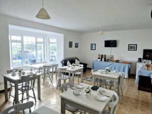 a dining room with white tables and chairs at The Shamrock B&B - Inis Oírr, Aran Islands in Inisheer