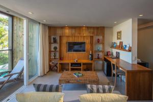 a living room with a desk and a television at Hotel Spa Nau Royal in Camburi