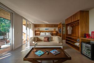 een slaapkamer met een bed en een salontafel bij Hotel Spa Nau Royal in Camburi