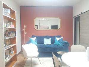 a living room with a blue couch and a mirror at Maison cosy citadine in Tours