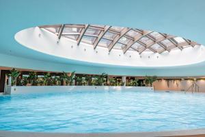 a large swimming pool in a building with a glass ceiling at HANZA TOWER GOLD 19th Floor in Szczecin