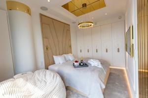 a bedroom with two beds and a chandelier at HANZA TOWER GOLD 19th Floor in Szczecin +34 photos