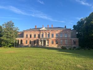 a large brick building with a large grass field at Ferienapartment Janow in Spantekow