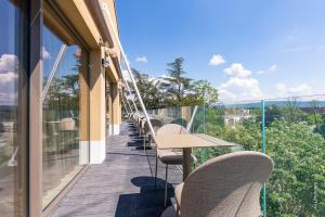 a balcony with chairs and a table on a building at HÔTEL PANORAMA 360 Bourg en Bresse - Cœur de ville in Bourg-en-Bresse