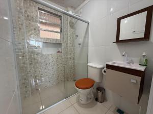 a bathroom with a shower and a toilet and a sink at Kit dos Sonhos – Frente Mar na Tupi! in Samaritá +13 photos