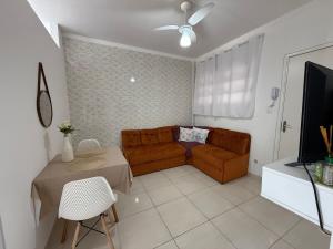 a living room with a couch and a table at Kit dos Sonhos – Frente Mar na Tupi! in Samaritá