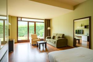 a hotel room with a bed and a living room at Indiana Boutique Hotel in Llanes