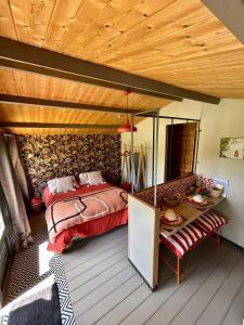 a bedroom with a bed and a wooden ceiling at Cabane romantique climatisée avec piscine en pleine nature in Montignac