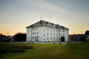 a large white building with a black roof at Hotel Raca in Sesvete