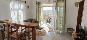 a dining room with a table and a balcony at La Residence Emmaüs in Rodrigues Island