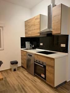 a kitchen with stainless steel appliances and wooden cabinets at Modern apartment Barcelona in Badalona