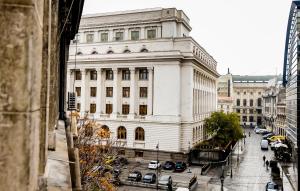 a large white building on a city street at Architectural Gem with Modern Flair - Double Studio Old Town in Bucharest