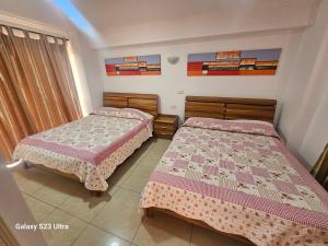 twee bedden in een kleine kamer met bij Santa Laura in Iquique