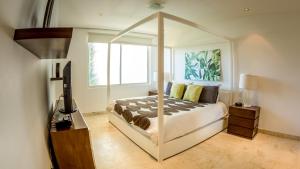 プラヤ・デル・カルメンにあるThe Elements Oceanfront & Beachside Condo Hotelのベッドルーム1室(天蓋付きベッド1台、窓付) +105枚の写真