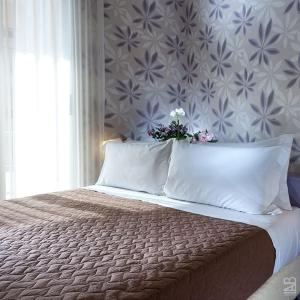 a bedroom with a bed with a flower arrangement on it at Hotel Estense in Bellaria-Igea Marina