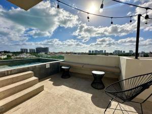 a patio with a bench and stairs on a building at Mangle 13 Modern Apartments-Rooftop pool, close to Ferry in Cancún