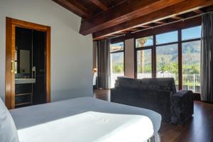 a bedroom with a bed and a couch and a window at Indiana Boutique Hotel in Llanes