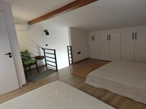 a bedroom with two beds and a chair in it at WOW Pool Feel Like Home Villa in Schinias +27 photos