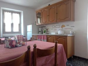 a kitchen with a table with a red table cloth at La corte del Gavi in Bosio