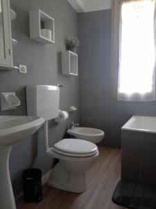 a bathroom with a white toilet and a sink at La corte del Gavi in Bosio +34 photos