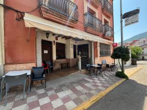 a table and chairs sitting outside of a building at Hotel Rural Cristina in Castañar de Ibor