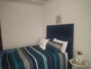 a bedroom with a bed with a striped blanket at Khetshane Consortium private park and restaurants in Ntswanahatshe