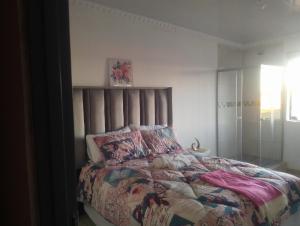 a bedroom with a bed with a colorful comforter at Khetshane Consortium private park and restaurants in Ntswanahatshe