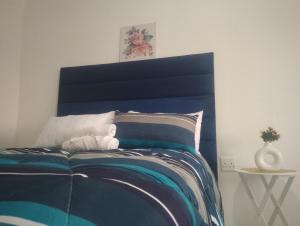 a bedroom with a bed with a blue headboard at Khetshane Consortium private park and restaurants in Ntswanahatshe +5 photos