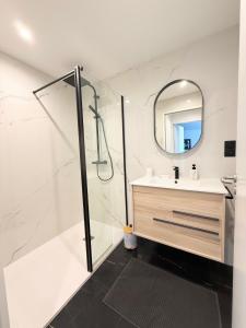 a bathroom with a shower and a sink and a mirror at Appartement standing calme in Rodez +11 photos