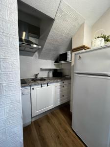 a kitchen with a white refrigerator and a sink at Marco Polo by Alina365 in La Manga del Mar Menor