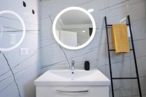 a white bathroom with a sink and a mirror at Apartment Grey in Medulin +42 photos