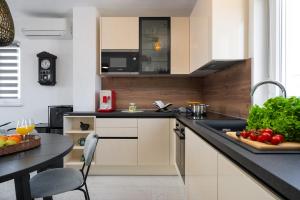 a kitchen with a sink and a table with fruits and vegetables at Apartment Grey in Medulin