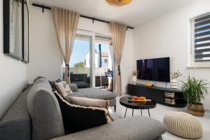 a living room with a couch and a tv at Apartment Grey in Medulin