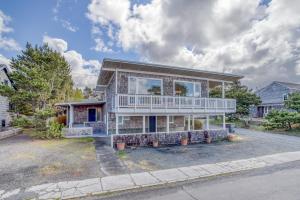 a large house with a balcony on a street at Ocean Avenue - Meredith Lodging in Gearhart
