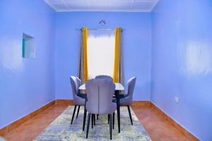 a dining room table with chairs and a window at WoodLands House in Naivasha +7 photos