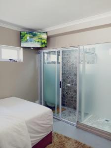 a bedroom with a bed and a glass shower at BKaap2 Queens and Kings Guest House in Cape Town