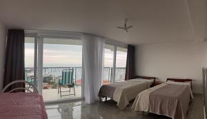 a bedroom with two beds and a balcony with a view at Apartment Light House in Dobra Voda