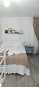 une chambre blanche avec un lit et une table bleue dans l'établissement La casa de los Abuelos, à Alcalá de los Gazules