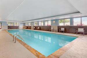 a large pool in a hotel with chairs and tables at Holiday Inn Express & Suites Nashville Southeast - Antioch by IHG in Antioch