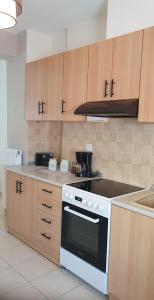 a kitchen with a white stove and wooden cabinets at Modern Apartment I & II by Irida Iris Group in Mytilini
