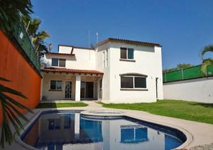a house with a swimming pool in front of it at Casa de fin de semana in Temixco