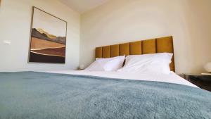 a bedroom with a large bed with a wooden headboard at Amorosa Beach Apartment Sea View in Viana do Castelo +41 photos