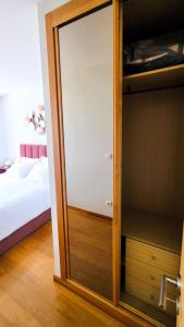 a glass door to a closet in a bedroom at Amorosa Beach Apartment Sea View in Viana do Castelo