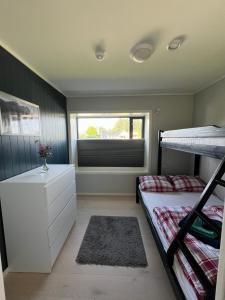 a bedroom with two bunk beds and a window at LofotenApartmentOne in Stamsund