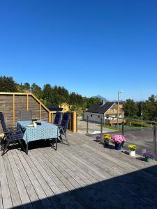a patio with a table and chairs on a deck at LofotenApartmentOne in Stamsund