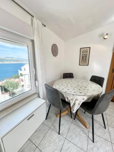 a dining room with a table and chairs and a window at Charming Apartments Dalmatian Misto Čiovo in Okrug Donji